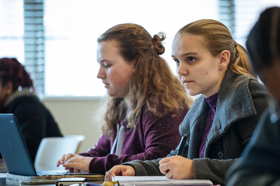 Group of students taking notes in class.